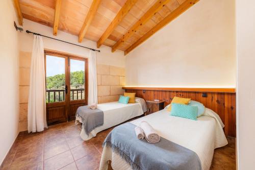 1 dormitorio con 2 camas y ventana en Es Sestador, en Petra