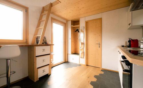 eine kleine Küche mit einer Treppe in einem winzigen Haus in der Unterkunft Tiny de l'Aigle in Villeret
