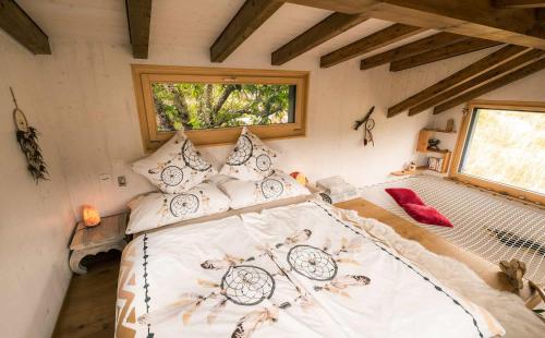 a bedroom with a large bed in a house at Tiny de l'Aigle in Villeret