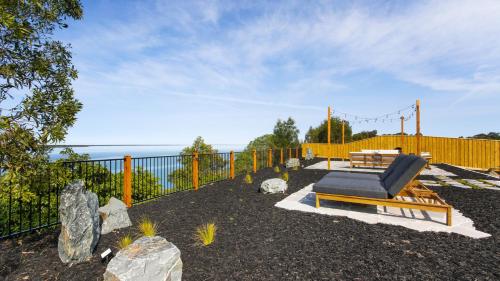 a patio with a bench and a table and a fence at Dreamviews at Metung in Metung