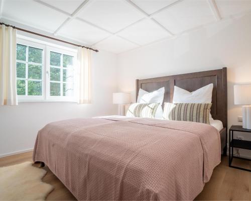biała sypialnia z dużym łóżkiem i oknem w obiekcie Strickerl w mieście Bad Goisern