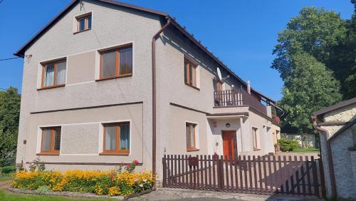 a house with a fence in front of it at Apartmán Budín - v klidu přírody, s parkováním in Nové Město nad Metují
