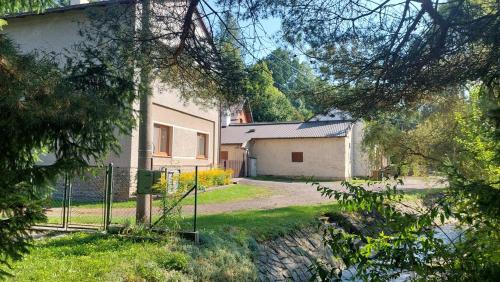 a house with a gate in the middle of a yard at Apartmán Budín - v klidu přírody, s parkováním in Nové Město nad Metují