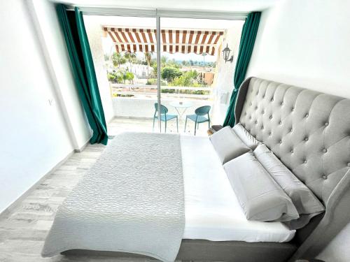 een slaapkamer met een groot bed en een groot raam bij Borinquen Vista Mar in Playa de las Americas