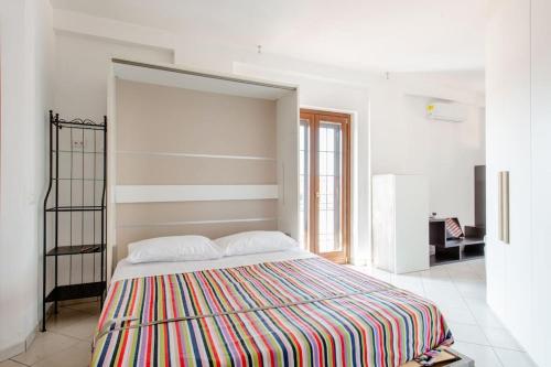 ein Schlafzimmer mit einem großen Bett und einer gestreiften Decke in der Unterkunft La Parmigiana in Marino