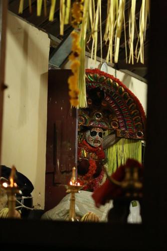 a view of a shrine with a mask and candles at Cranganor History Café & Riverside Château in Parūr