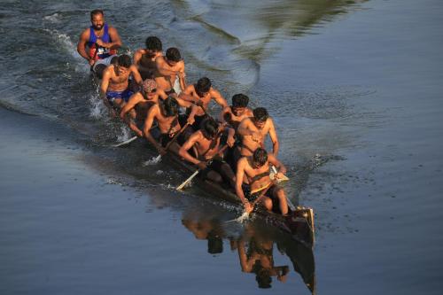a group of people in a boat on the water at Cranganor History Café & Riverside Château in Parūr