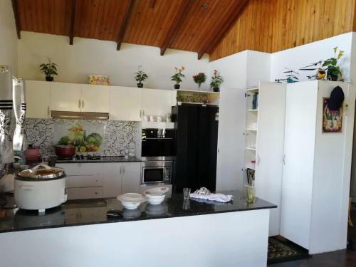 a kitchen with white cabinets and a black refrigerator at Fiji-Beauty in Nadi