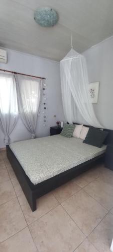 a bedroom with a bed with mosquito nets on it at Εξοχικό MARIA in Ambelákia