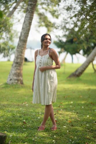 a woman in a dress standing in a park at Cranganor History Café & Riverside Château in Parūr