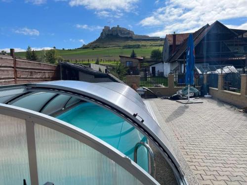 a house with a roof with a mountain in the background at A+S Penzion Podzamok in Spišské Podhradie