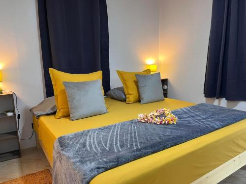 a yellow bed with yellow pillows and flowers on it at Elisabeth Lodge Vairupe in Bora Bora