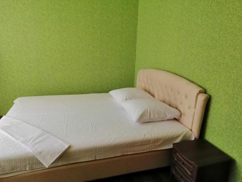 1 dormitorio con 1 cama con pared verde en Шевченка 241. Центр. en Cherkasy