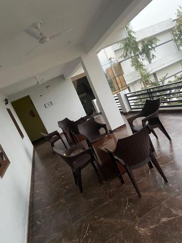 a dining room with chairs and a table and windows at Skylight homestay in Dehradun