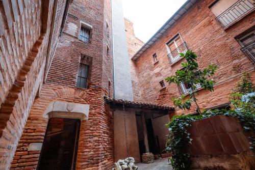 an alleyway in an old brick building at une pause sur la place Royale in Montauban