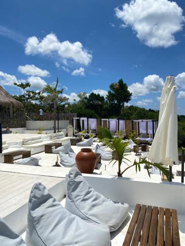 a patio with tables and chairs and a white umbrella at RUNIK Siquijor - Adults Only in Siquijor