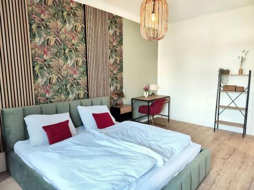 sypialnia z dużym łóżkiem z 2 czerwonymi poduszkami w obiekcie tealounge 2 Raum + Küche w Dreźnie