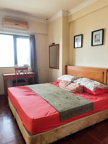a bedroom with a large bed with a red blanket at lanai gurney corporate suites in Kuala Lumpur