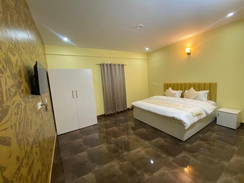 a bedroom with a bed and a flat screen tv at Skylight homestay in Dehradun