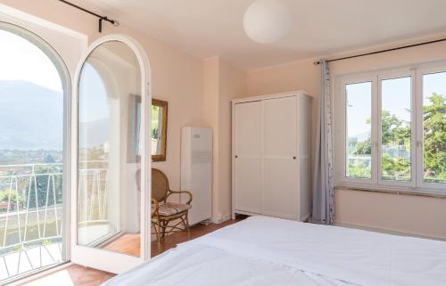 a bedroom with a bed and large windows at Villa Incanto in Ascona