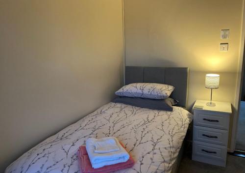 a bedroom with a bed with two towels on it at 3 Bedroom Apartment, Ballymena, The Wee Stop Gap in Ballymena