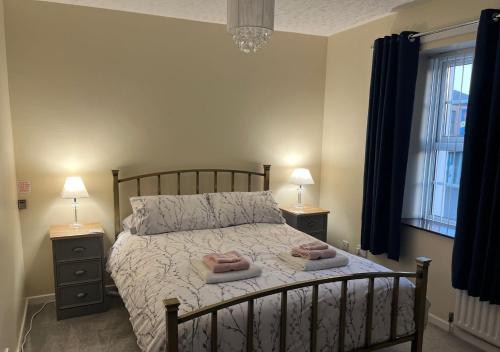a bedroom with a bed with two towels on it at 3 Bedroom Apartment, Ballymena, The Wee Stop Gap in Ballymena