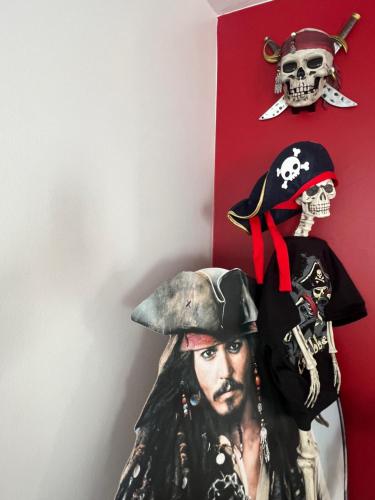 una estatua de un pirata y un cráneo en una pared en THE ENCHANTED HOUSE ( 15 min walk to Disney), en Serris