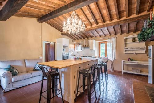 a kitchen and living room with a large island with bar stools at Glicine in Montieri