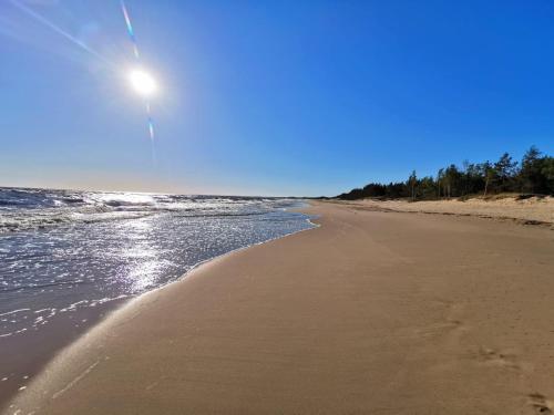una playa con el sol brillando en la arena en M&K Apartamenty Przystań Świbno, en Gdansk