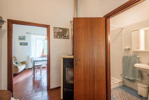 Baño con puerta que da a una habitación con lavabo en Lavanda, en Montieri