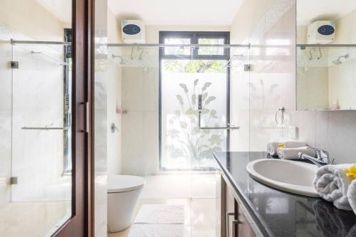 a bathroom with a sink and a toilet at Jenna Residence Denpasar in Denpasar