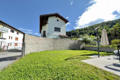 una pared de ladrillo con césped delante de una casa en Casa Carolina 1 and Casa Carolina 2 - Happy Rentals, en Losone