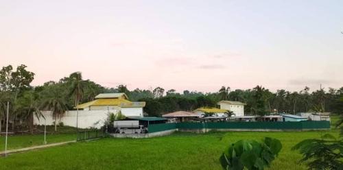 a group of buildings in a field of grass at green aa garden resort in Sikatuna