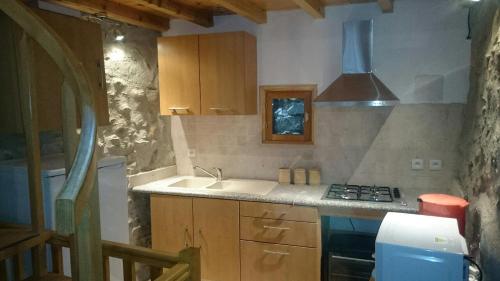 uma cozinha com um lavatório e um fogão em La grange à Goulier em Goulier-et-Olbier