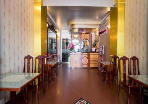 een eetkamer met tafels en stoelen in een restaurant bij Tan Hoang Long Hotel in Ho Chi Minh-stad