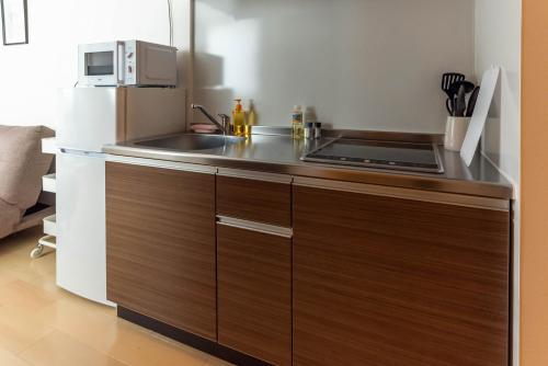 a small kitchen with a sink and a refrigerator at FDS Liberta in Osaka
