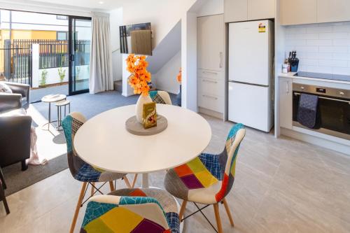 a kitchen and dining room with a table and chairs at Vibrant Inner City Escape Near New Regent Street in Christchurch