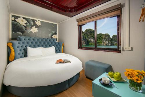 ein Schlafzimmer mit einem großen Bett und einem Fenster in der Unterkunft Halong Fantasea Cruise in Hạ Long
