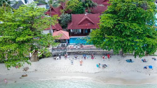 a group of people on a beach in front of a building at Bhundhari Chaweng Beach Resort Koh Samui - SHA Plus in Chaweng