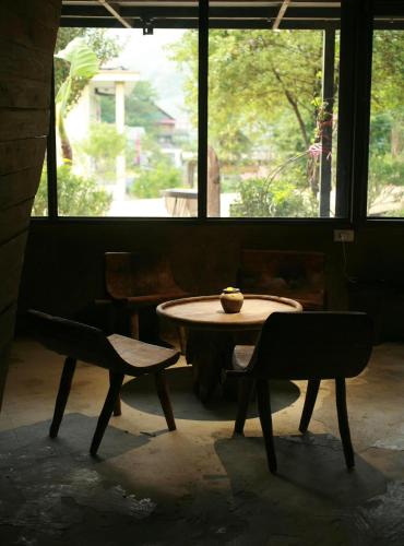 a table and chairs in a room with a window at Sa Moc - La Maison House & Bungalow in Sa Pa