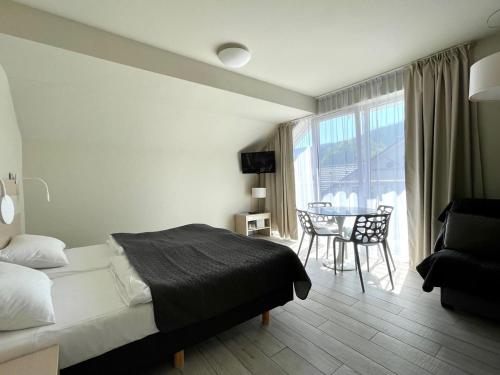 a bedroom with a bed and a table and a window at Apartament Ischgl 35 in Sienna