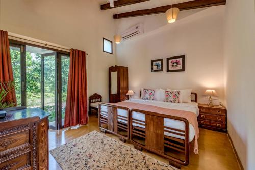a bedroom with a bed and a large window at SaffronStays Elderflower in Alibaug