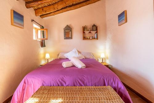 a bedroom with a purple bed with two pillows at Zarzamora de Rubite in Rubite