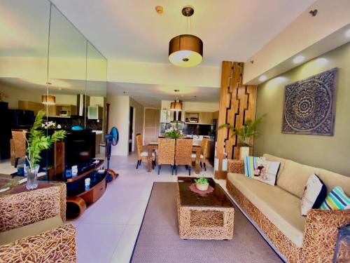 a living room with a couch and a table at Pico De Loro 2BR Carola B Unit with Lagoon View in Nasugbu