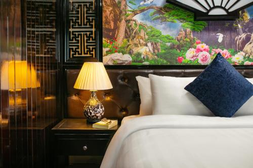 a bedroom with a bed and a lamp on a table at Halong Fantasea Cruise in Ha Long