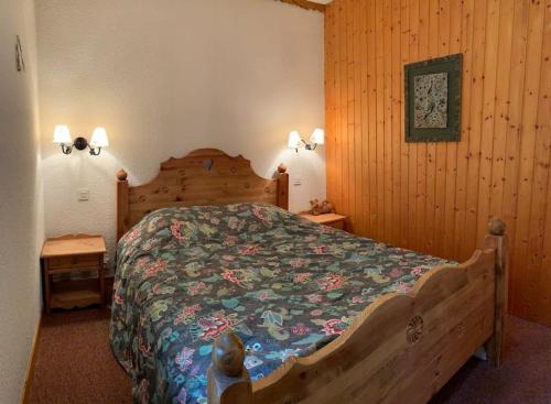 - une chambre avec un lit en bois et 2 tables dans l'établissement Résidence Saboia A29 Clés Blanches Courchevel, à Courchevel