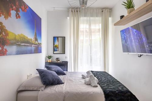 - une chambre dotée d'un lit avec des oreillers et d'une grande fenêtre dans l'établissement Cozy Studio near the Eiffel Tower, à Paris