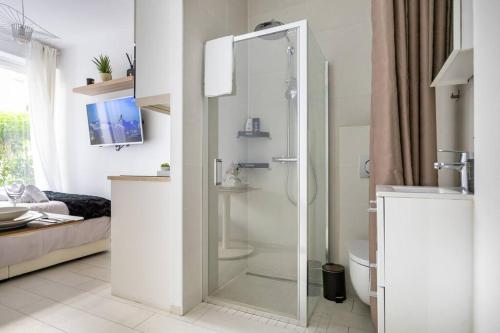 une salle de bain avec une douche avec une porte vitrée dans l'établissement Cozy Studio near the Eiffel Tower, à Paris