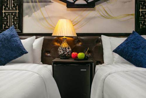 a room with two beds with a lamp on a table at Halong Fantasea Cruise in Ha Long
