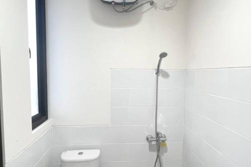 a white bathroom with a shower and a toilet at Villa Rolling Hills Depan Trans Mall Makassar in Makassar